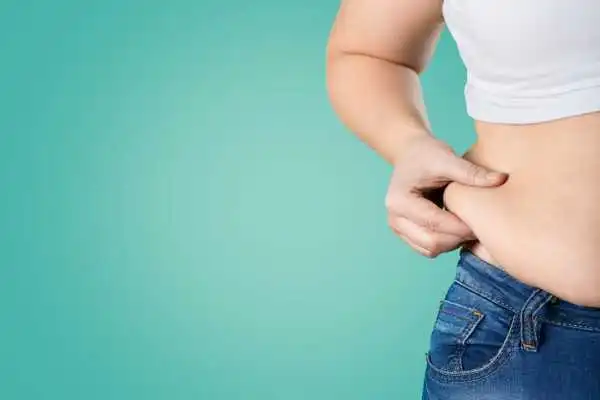 Image of woman pinching her love handles to show weight gain Bibury